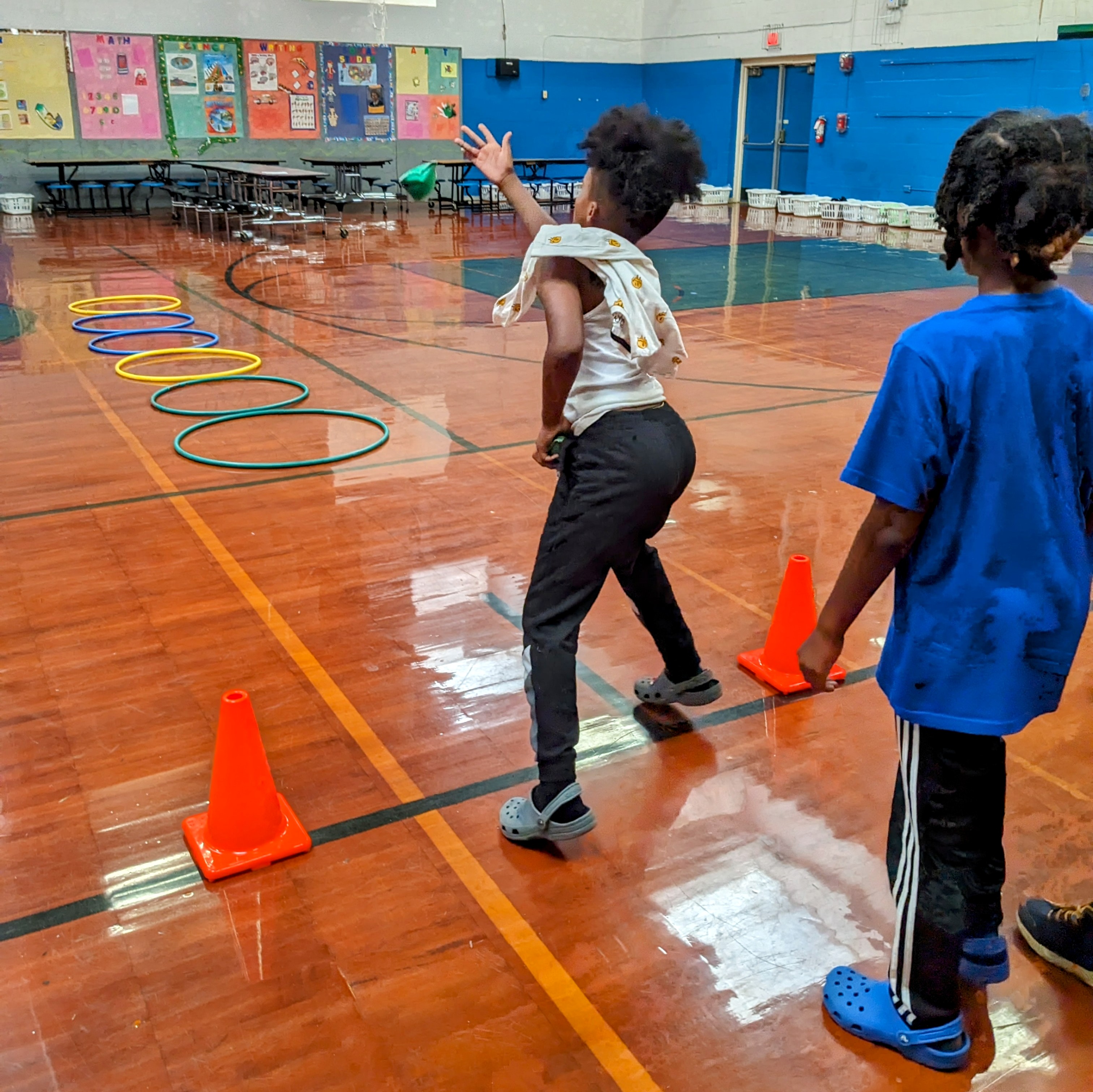 Boys playing a toss game with hula hoops.